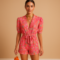 Short printed jumpsuit for women with a built-in belt and vibrant design, suitable for warm days, evenings out, and summer occasions.